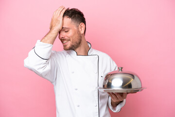 Young Brazilian chef with tray isolated on pink background has realized something and intending the solution