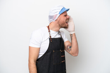 Fishmonger man wearing an apron isolated on white background shouting with mouth wide open to the lateral