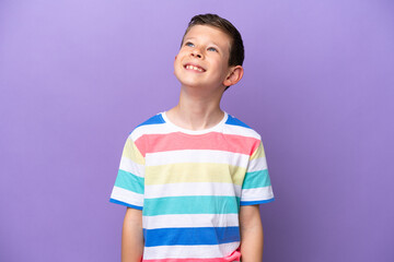 Little boy isolated on purple background thinking an idea while looking up
