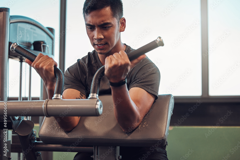 Sticker Gotta get these guns in popping. Shot of a young man working out in the gym.