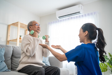 Asian older aged man doing physiotherapist with support from nurse. 