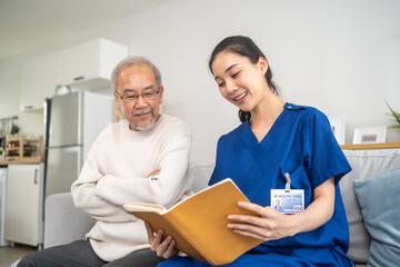 Obraz premium Asian woman caregiver take care of senior elderly male at nursing home