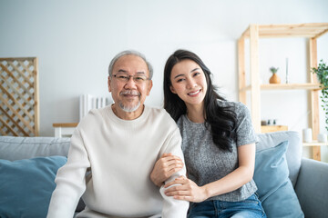 Portrait of Asian beautiful daughter hugging and sit with older father - obrazy, fototapety, plakaty