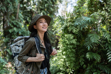 Asian young beautiful female backpacker traveling alone in forest wild