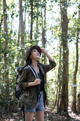 Fototapeta na wymiar Asian young beautiful female backpacker traveling alone in forest wild