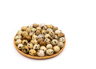Raw quail eggs on a white background on a plate, top view, healthy eating concept
