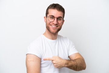 Young caucasian man wearing band aids isolated on white background and pointing it