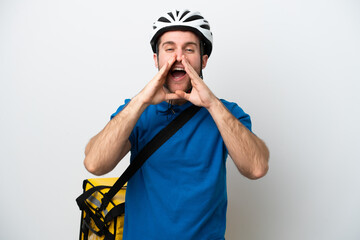 Young caucasian man with thermal backpack isolated on white background shouting and announcing something