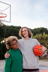 two friends smiling happy after playing basketball