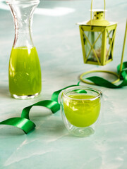 Green drink in glass and bottle
