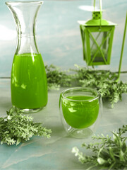 Green drink in glass and in bottle