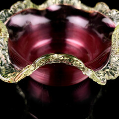 crystal antique figurative vase of pink color. vintage glass red vase in the shape of a flower on a black isolated background