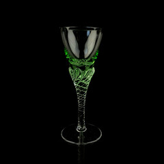 green antique crystal frame. vintage glass with a curly stem on a black isolated background