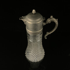 antique glass decanter with geometric pattern. retro decanter for alcohol on a black isolated...