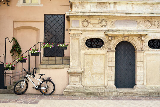 Old vintage stone Entrance door on street with bike and flowers 