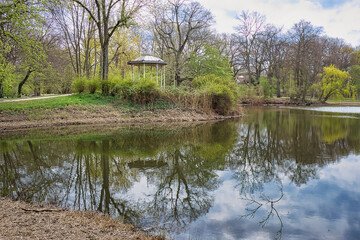 Fototapeta na wymiar Teich im Park Palmengarten mit Pavillion im Hintergrund, in Leipzig, Sachsen, Deutschland