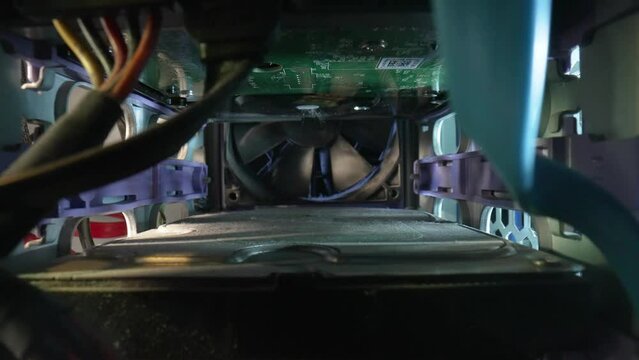 Camera movement inside an old dusty computer system unit. The camera zooms in on the cooler, the fan is covered in dust. Close up computer components, digital technology, electronic equipment Pc.