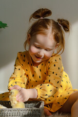 Girl in a yellow dress with a basket of chickens