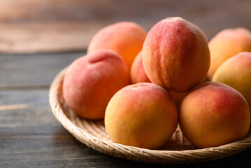 Peach fruit in basket on wooden background