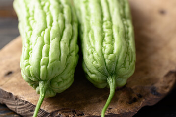 Bitter melon or bitter gourd on wooden background, Organic vegetables from local market in Thailand