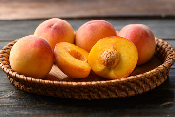 Peach fruit in basket on wooden background