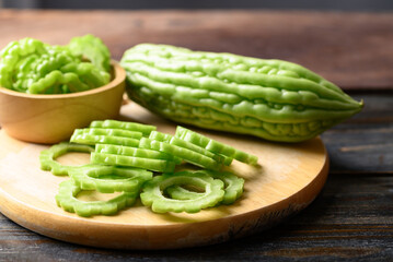 Sliced bitter melon or bitter gourd on wooden board prepare for cooking