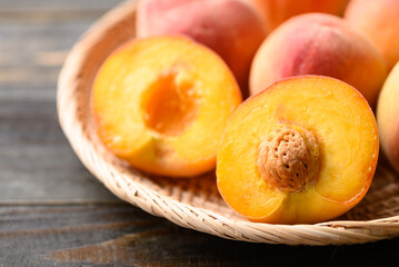 Peach fruit in basket on wooden background