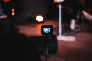 a man shoots a video on an action camera at a concert