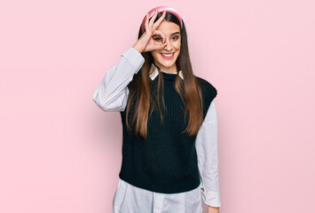 Young beautiful woman wearing casual white shirt doing ok gesture with hand smiling, eye looking through fingers with happy face.