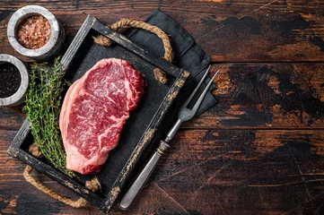 Fotobehang Prime raw new york beef meat steak with herbs ready for cooking. Wooden background. Top view. Copy space © Vladimir