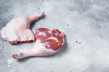 Fresh raw duck legs on a kitchen table. Gray background. Top view. Copy space