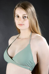 Portrait of a beautiful girl posing in green bikini in studio