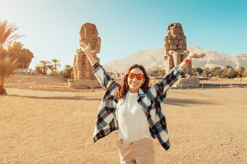 Happy tourist girl interested in Egyptology and archaeology and gets a travel experience at the...