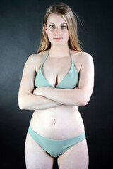 Beautiful girl posing in green bikini in studio