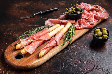 Meat appetizer platter with grissini sticks, Prosciutto crudo, Salami and Coppa Sausage and olives....