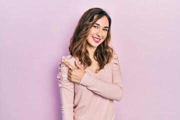 Young hispanic girl wearing casual clothes smiling cheerful pointing with hand and finger up to the side