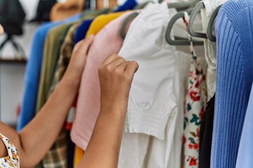 Young hispanic woman shopping at clothing store