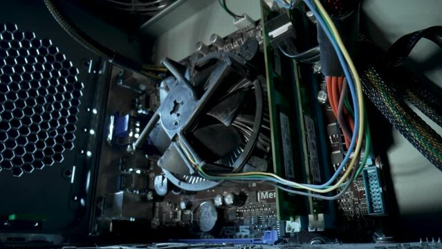 Camera movement inside an computer system unit. The camera zooms in on cooler. Shooting in motion, PC inside, wires and structure of computer. Close up computer components, electronic equipment Pc.