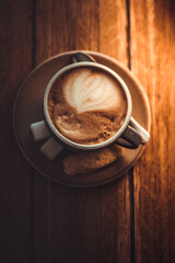 A cup of coffee on a wooden background close-up. Coffee on a platter. Coffee, biscuits, sugar and a spoon