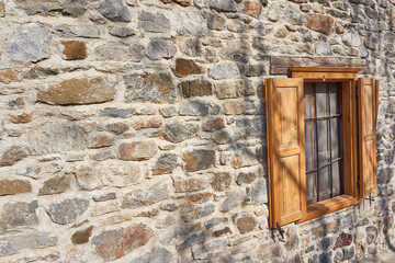 Country house wooden window in stone wall
