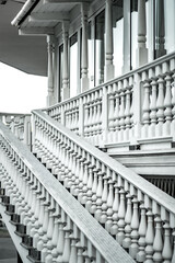 White staircase with balusters. Bright building with a beautiful staircase. Repetitive elements in architecture. Marble staircase in the restaurant