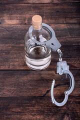 The concept of liberation from alcohol addiction, a bottle of alcohol and unfastened handcuffs