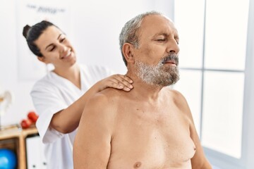 Physiotherapist and patient smiling confident having rehab session at clinic