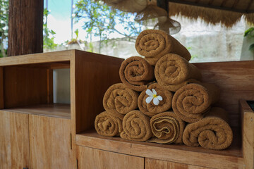 Brown spa towels arranged at lounge of swimming pool 