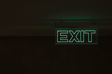 Green Exit Sign Isolated In Dark Black Room