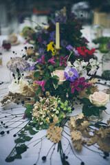 Floral centerpiece with roses, anemone, daisies and candle