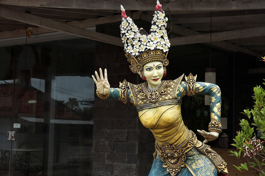 A granite statue of an exotic Balinese cultural legong maiden dancer in traditional costume. Bali Indonesia, December 2021