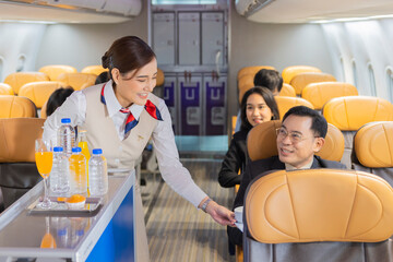 The cabin crew pushing the cart on aisle to serving food and drink water, orange juice to...