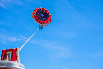 Parasailing under the blue sky at tropical islands. Holiday fun activities. Copy space for tourism and love relationship 