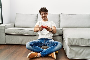 Young hispanic man smiling confident playing video game at home © Krakenimages.com